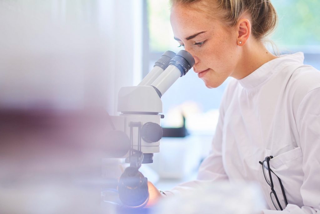 Photograph of a scientist looking in a microscope