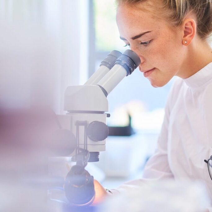 Photograph of a scientist looking in a microscope