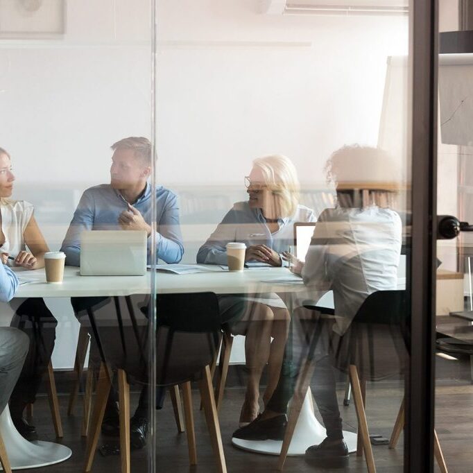 Five people sitting in a conference room during a meeting