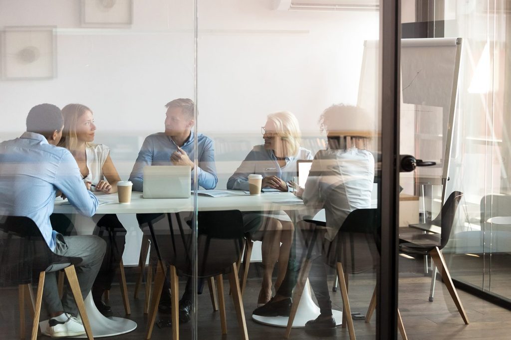 Five people sitting in a conference room during a meeting